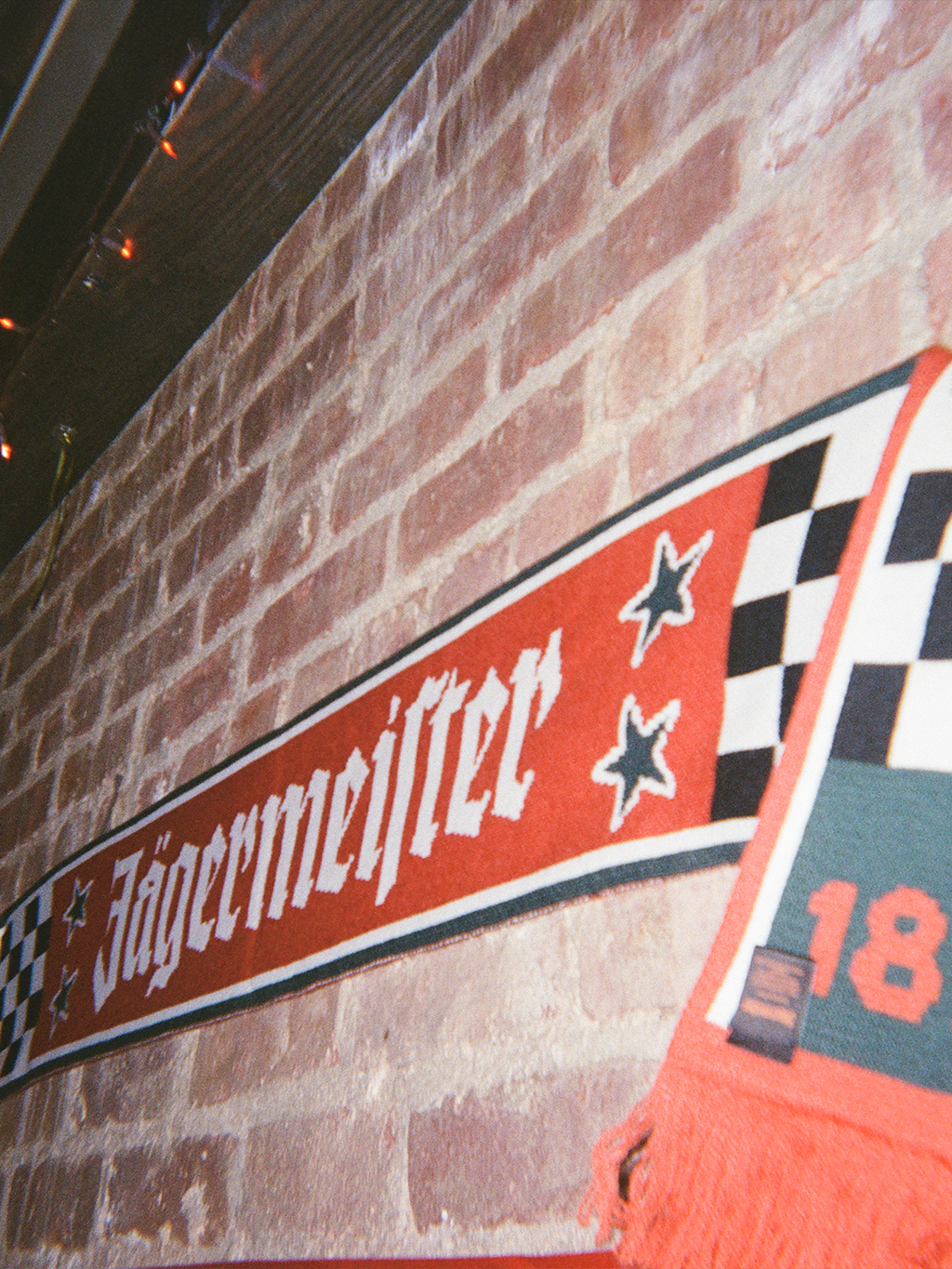 Sciarpa Jägermeister Racing contro una parete di mattoni.