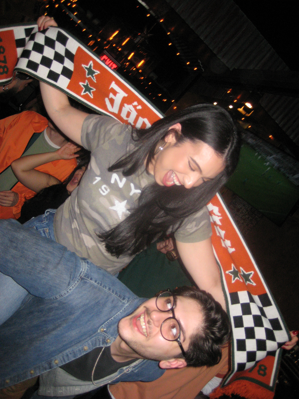 Due persone in posa con una grande sciarpa Jägermeister Racing