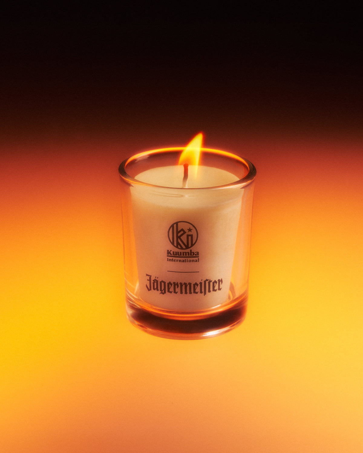 Jagermeister candle in a glass container with a dark background
