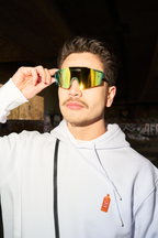 Persona che indossa occhiali da sole riflettenti Jägermeister e una felpa con cappuccio bianca con un logo a forma di bottiglia.