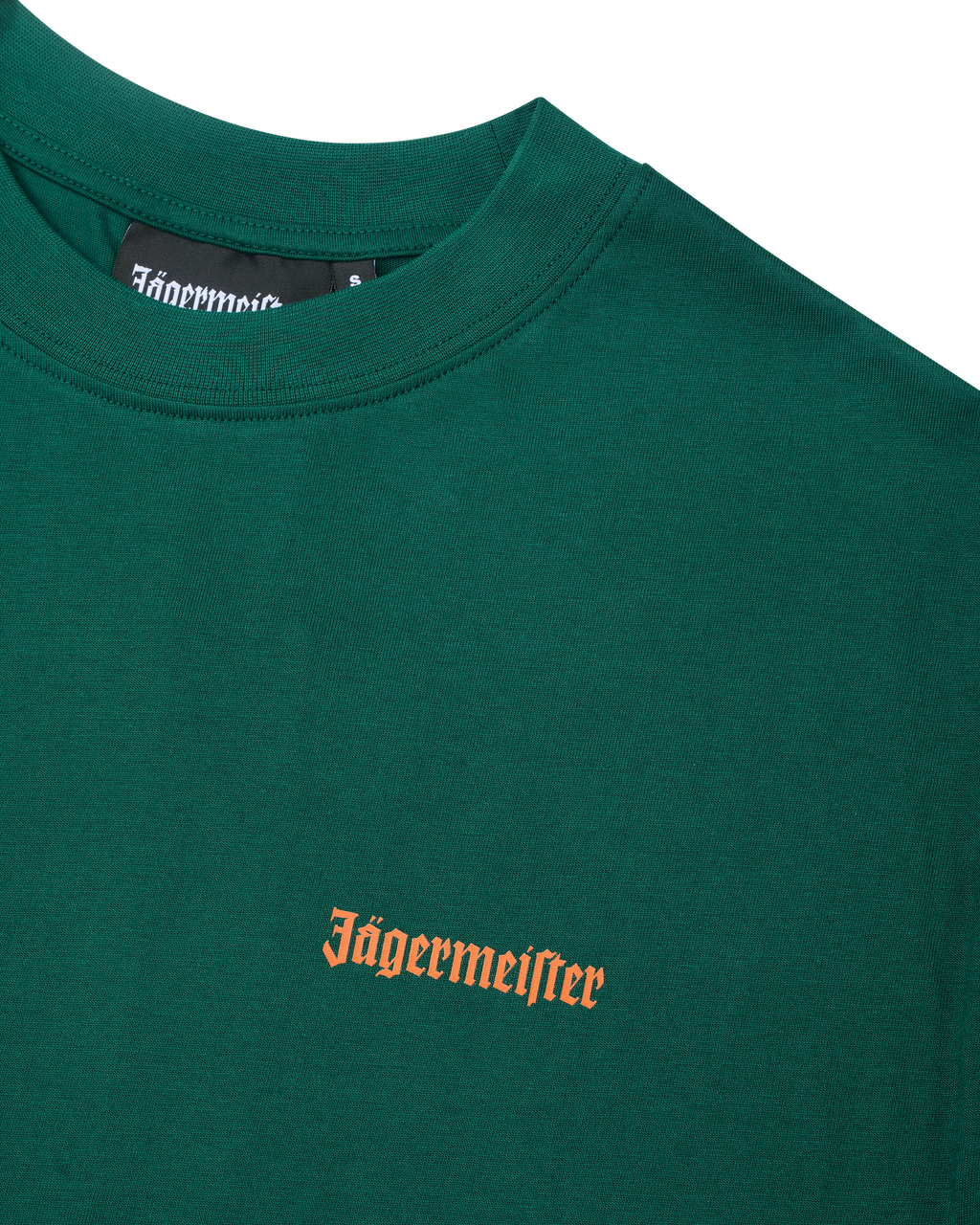 T-shirt verde Jägermeister con un wordmark arancione Jägermeister sul petto.