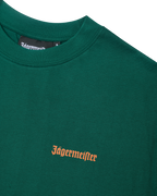 T-shirt verde Jägermeister con un wordmark arancione Jägermeister sul petto.