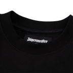 Primo piano del colletto di una T-shirt nera Jägermeister con un’etichetta tessuta con logo Jägermeister all’interno dello scollo.