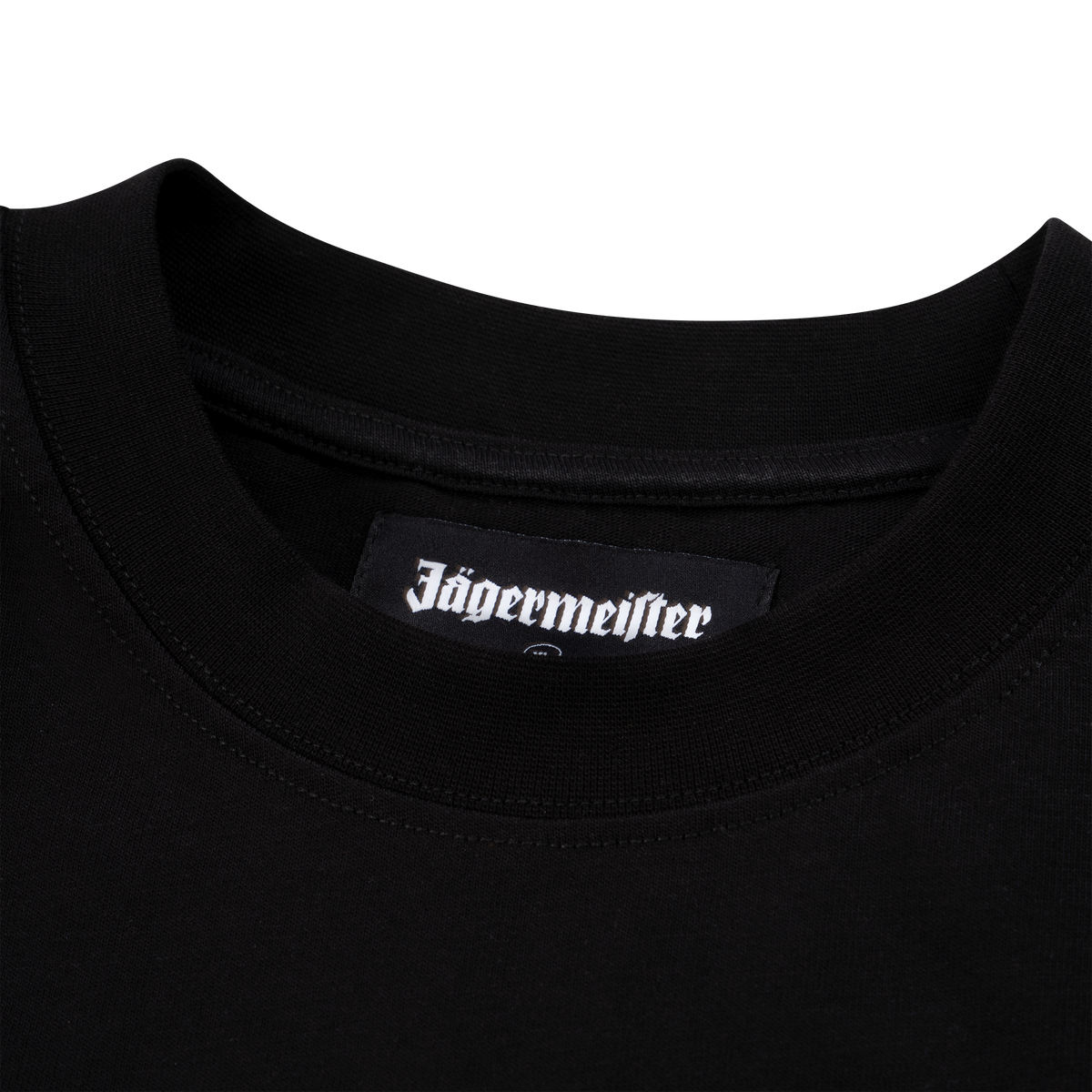 Primo piano del colletto di una T-shirt nera Jägermeister con un’etichetta tessuta con logo Jägermeister all’interno dello scollo.