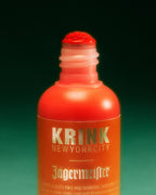 Pennarello arancione Krink con branding Jägermeister su sfondo verde