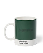 Tazza Jägermeister con campione colore Pantone Herbal Green su sfondo bianco