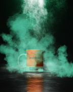 Tazza con testo 'Jagermeister' e 'Pantone Culture Orange', circondata da fumo colorato su sfondo scuro