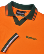 Polo arancione Jägermeister con colletto verde e rifiniture arancioni con branding verde Jägermeister.