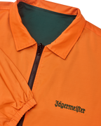 Primo piano della giacca reversibile Jägermeister con cerniera, con il lato arancione visibile