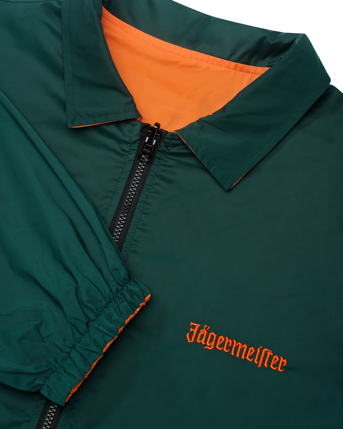 Primo piano della giacca reversibile Jägermeister con cerniera, con il lato verde visibile