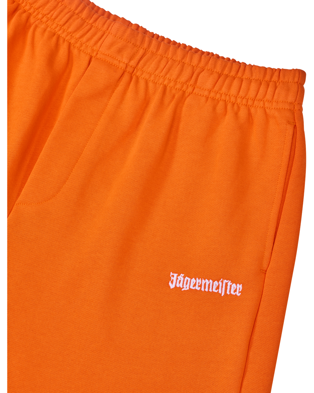 Primo piano di pantaloni arancioni con logo bianco Jägermeister.