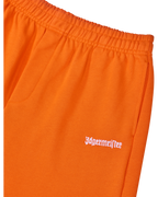 Primo piano di pantaloni arancioni con logo bianco Jägermeister.