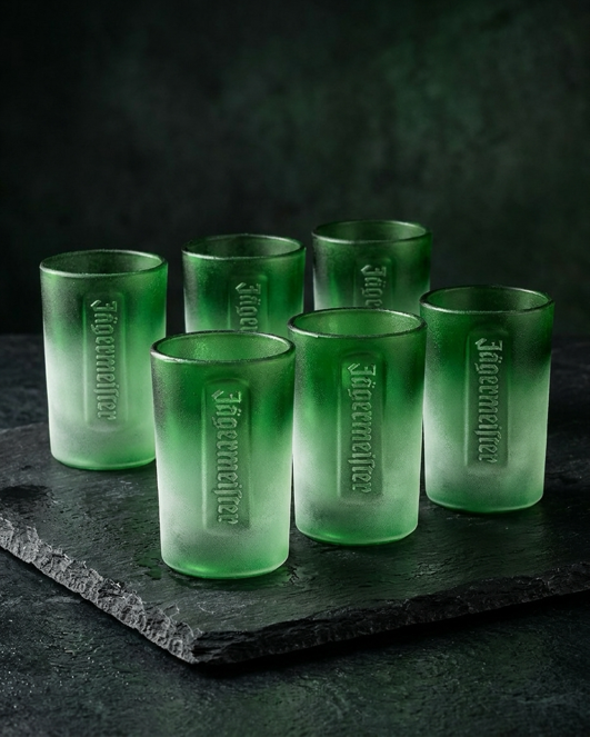 Set di sei shot glass verdi con scritta Jägermeister in rilievo su una superficie scura