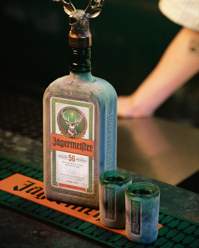 Bottiglia Jagermeister con due shot glass sul bancone di un bar