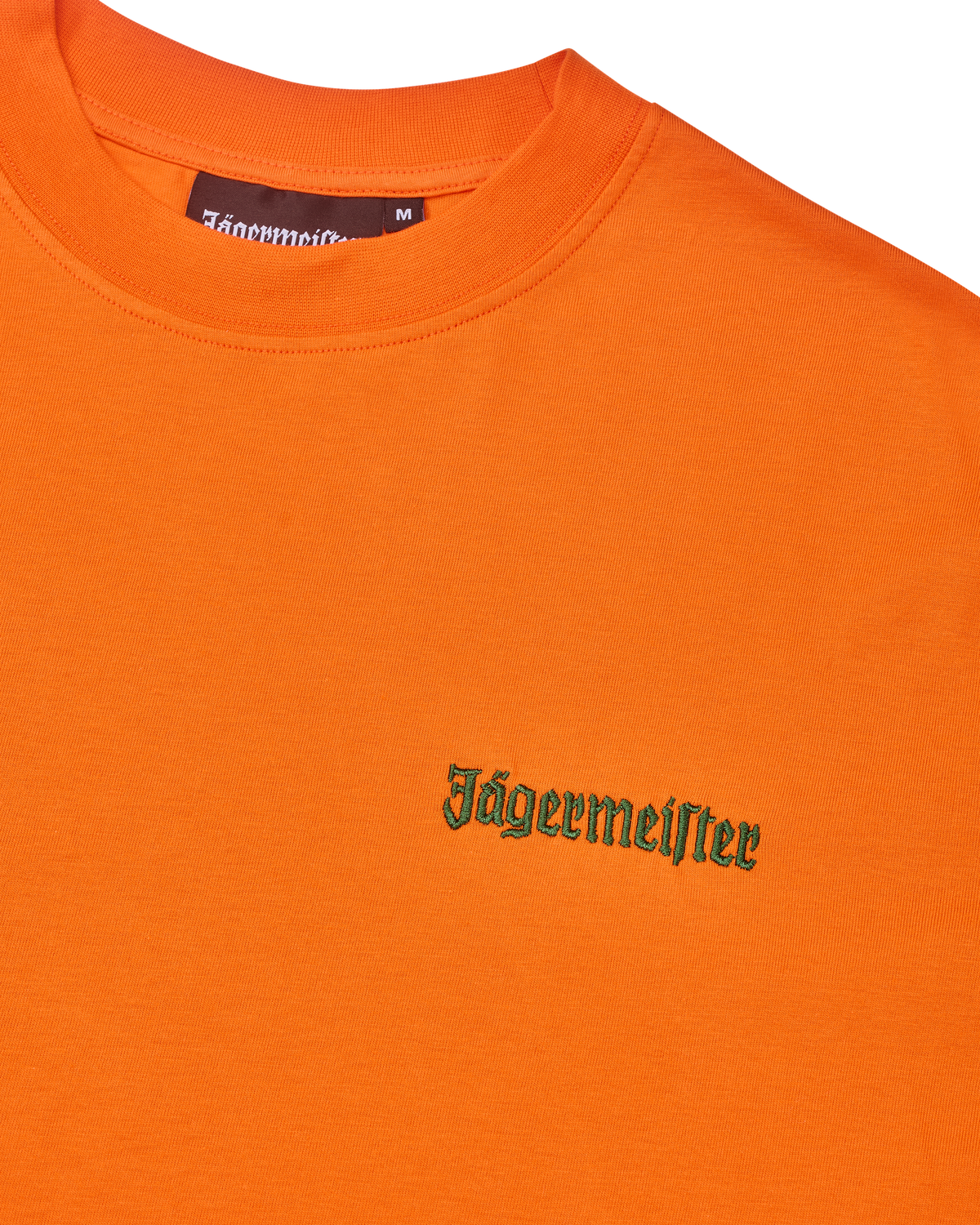 T-shirt arancione con logo Jägermeister verde sul petto.