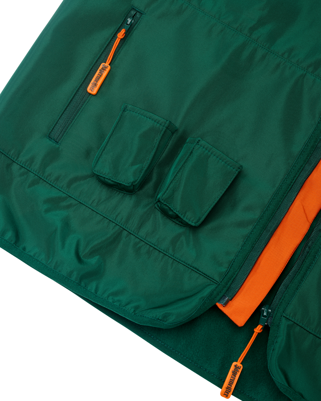 Gilet verde con dettagli arancioni e due piccole tasche per i Jägermeister Minis.