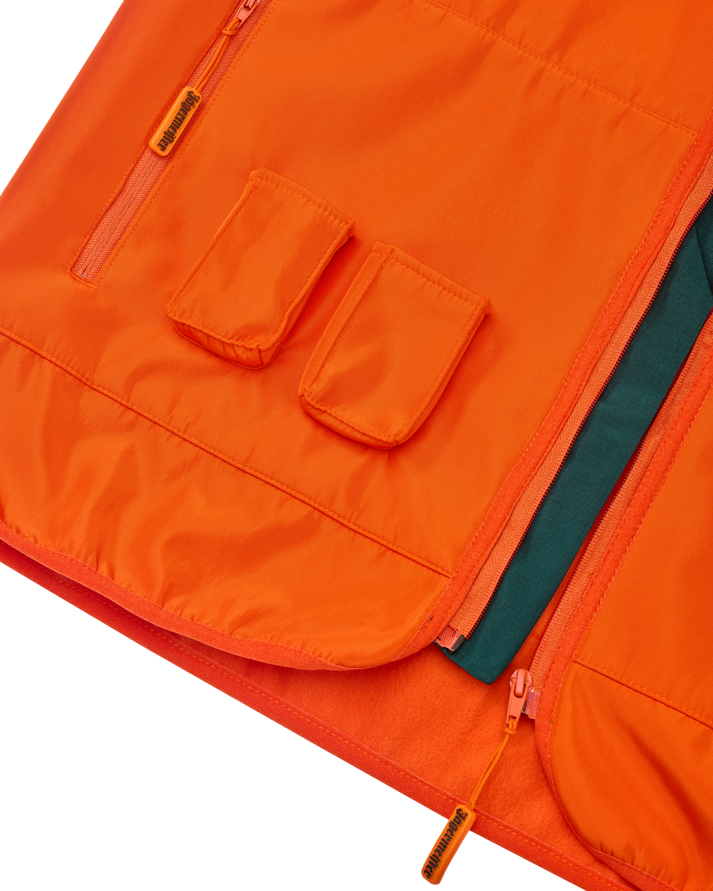 Primo piano di un gilet arancione Jägermeister con due tasche frontali per i Jägermeister Minis.