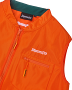 Primo piano di un gilet arancione con branding Jägermeister bianco.