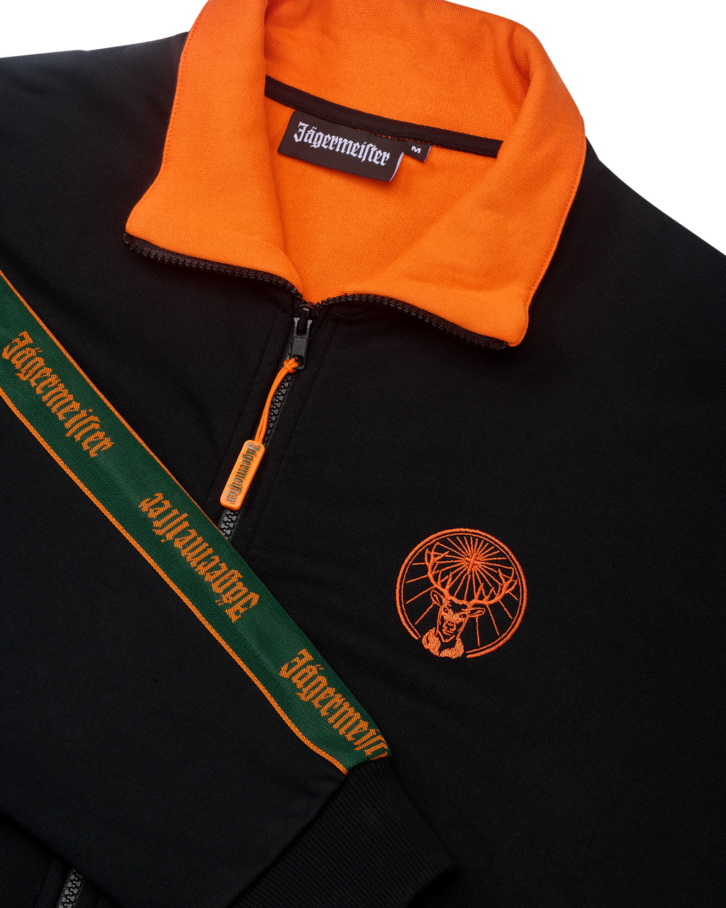 Giacca nera con colletto arancione e branding Jägermeister sul petto e sulla manica.