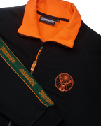 Giacca nera con colletto arancione e branding Jägermeister sul petto e sulla manica.