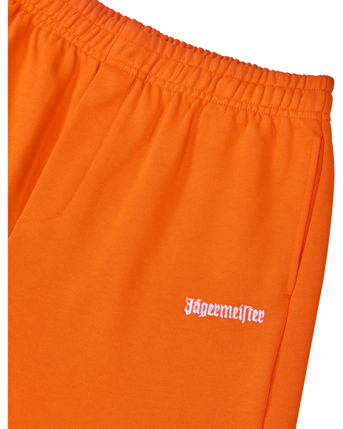 Pantaloni della tuta arancioni con logo Jägermeister bianco sul lato.