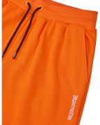 Pantaloni della tuta Jägermeister arancioni con cordino nero e logo bianco.
