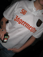 Person wearing a white jersey with 'Jägermeister' branding, holding a Jägermeister Mini.
